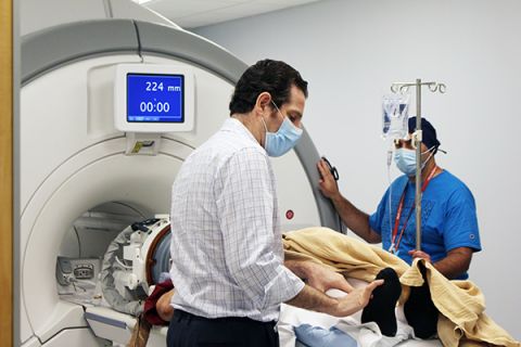 Between pulses of ultrasound energy, Dr. Kaplitt and MRI technician Aldo Cappone check on the patient's progress